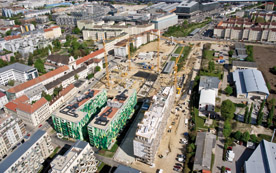 Die Luftaufnahme zeigt, dass die Baustelle auch eine große logistische Herausforderung ist. Mehr als 130 Mitarbeiter sind aktuell auf den drei Bauplätzen tätig. Die Baustellenzufahrt muss aufgrund der baulichen Veränderungen im Umfeld laufend geändert werden. Dazu drängt die Zeit – Ende Mai startet die Stadt Wien mit dem Straßenbau.